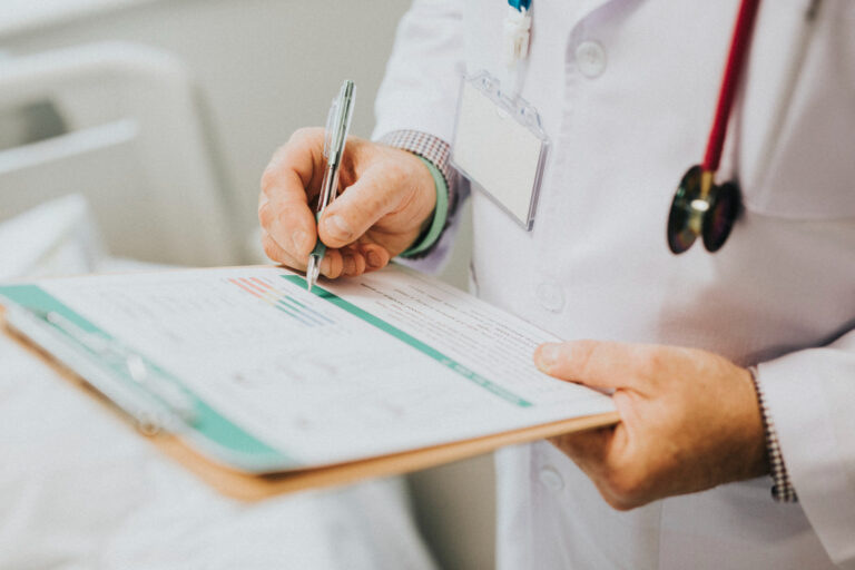 Doctor con estetoscopio revisando récord médico tras accidente de auto